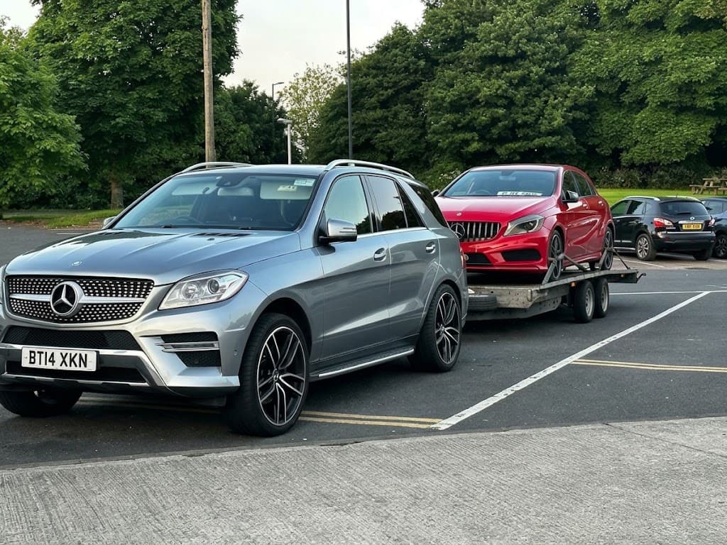 A Mercedes ML towing a red Mercedes A-Class on a trailer